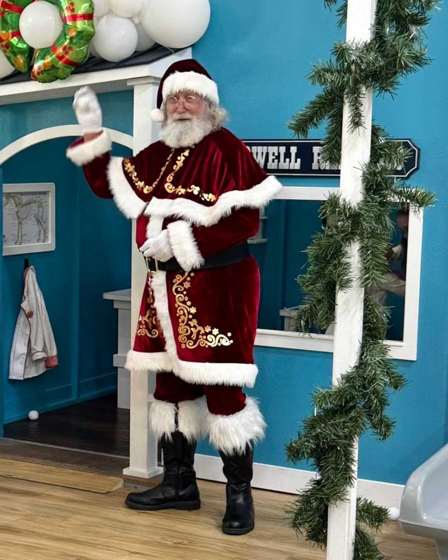 Santa waving outside the Lady Bird Animal Clinic in Tiny Town