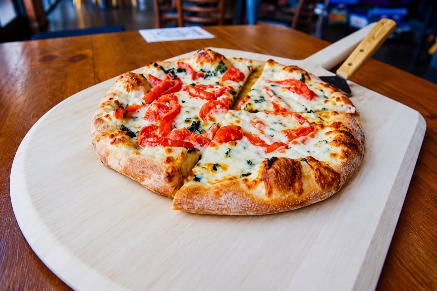 A fresh pizza on a wooden peel from CraigO's, our preferred pizza vendor