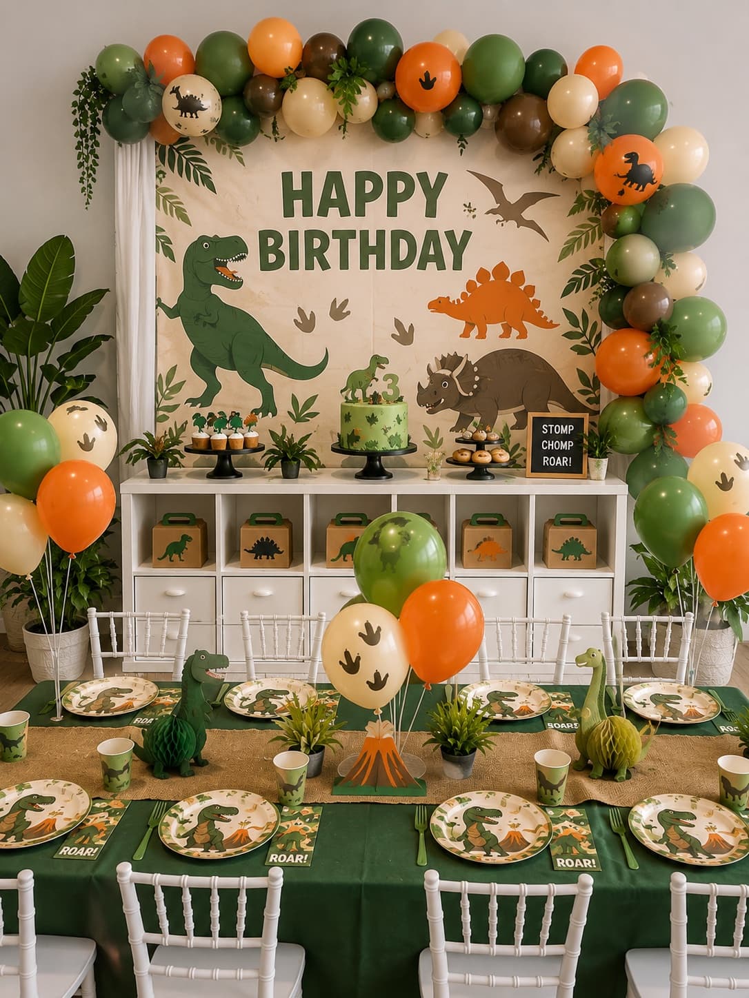 Dinosaur birthday party setup with green and orange balloon garland