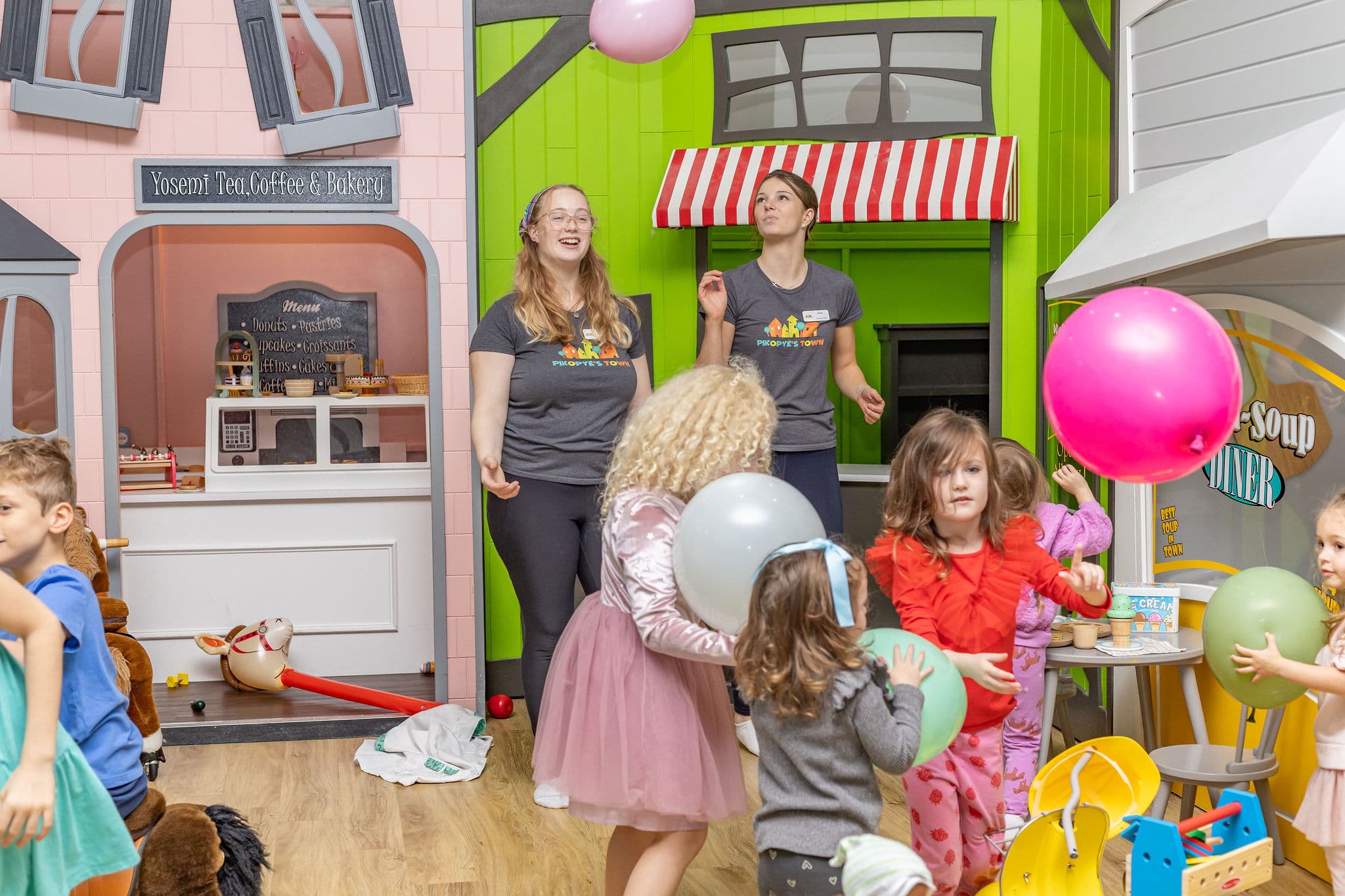 Party host leading a balloon activity with kids