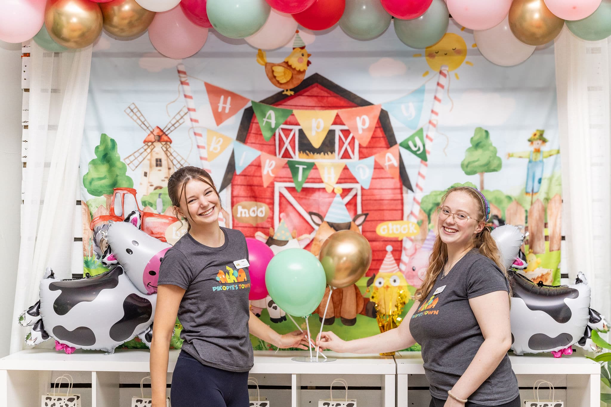 Party hosts smiling in front of backdrop