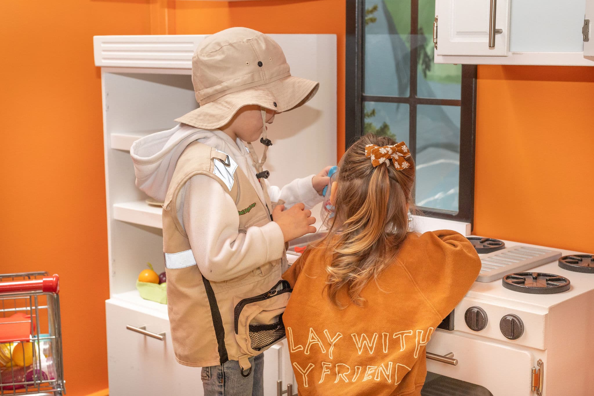 Kids playing in the kitchen playhouse